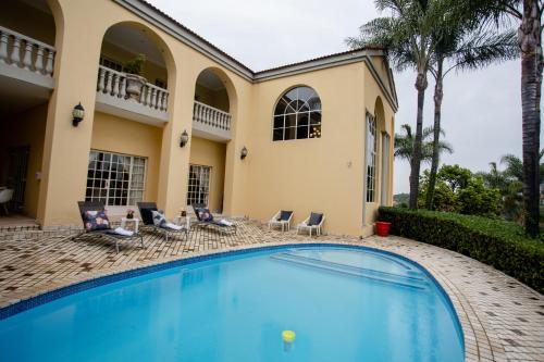 a swimming pool in front of a house at TDM's Boutique Guest House in Pretoria