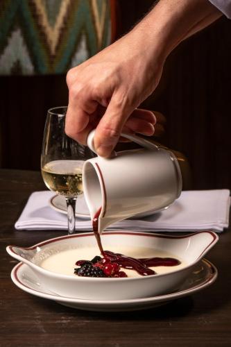 a person pouring wine into a plate of food at Sublime Lisboa in Lisbon