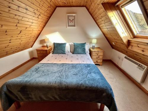 a bedroom with a large bed in a attic at Orchid Cottage in Lairg