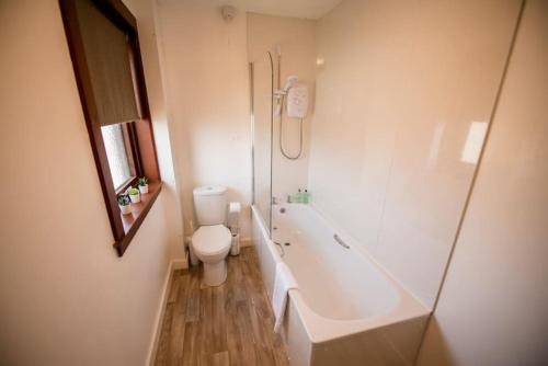 Un baño con inodoro, bañera y lavabo. en Banff House, en Fort William