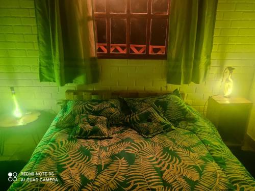 1 cama con edredón verde en un dormitorio en Entre Nubes 