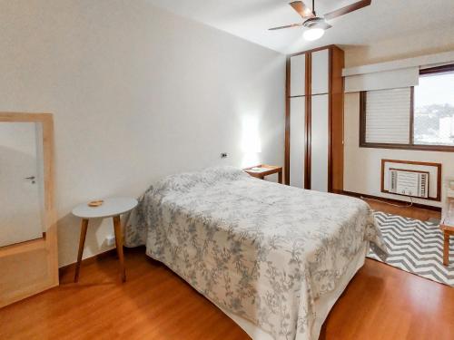 1 dormitorio con cama, mesa y ventana en Apart Hotel Barra Leme com Vista Mar e Montanha B1-001, en Río de Janeiro