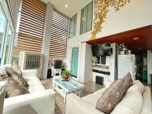 a living room with a couch and a tv at Peak Boutique City Hotel Krabi in Krabi