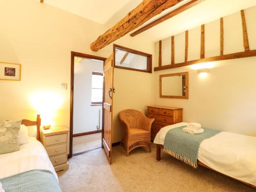 a bedroom with two beds and a mirror at The Granary in Colchester