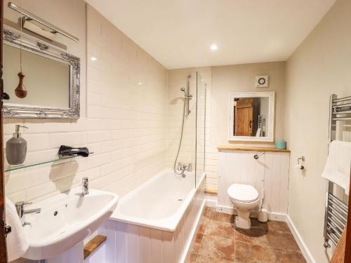 a bathroom with a sink and a tub and a toilet at The Granary in Colchester