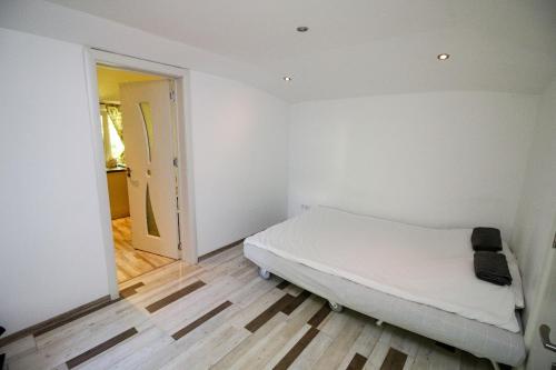 a white bedroom with a bed and a hallway at Charming loft, very good located! in Sofia