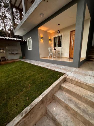 una casa con porche con césped y escaleras en Casas do Serrano, en Lençóis