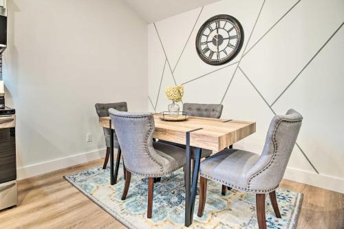 a dining room table with chairs and a clock on the wall at Modern Apt Near Marthas Vineyard Beaches! in Oak Bluffs
