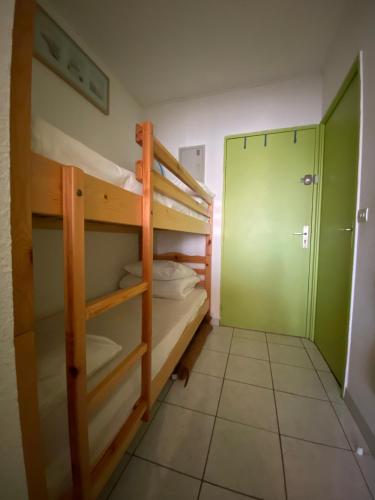 une chambre avec deux lits superposés et une salle de bain dans l'établissement Studio La Désirade Centre Port avec parking, au Cap d'Agde