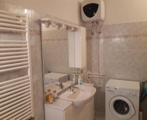 ein Badezimmer mit einem Waschbecken und einer Waschmaschine in der Unterkunft Casa del Sorriso in Elmo
