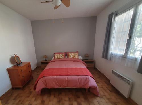 une chambre avec un lit et un ventilateur de plafond dans l'établissement L'OREE DU GOLF, à Mandelieu-la-Napoule