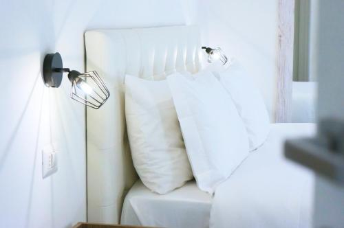 a white bed with two white pillows on it at The Roman Way San Giovanni in Rome