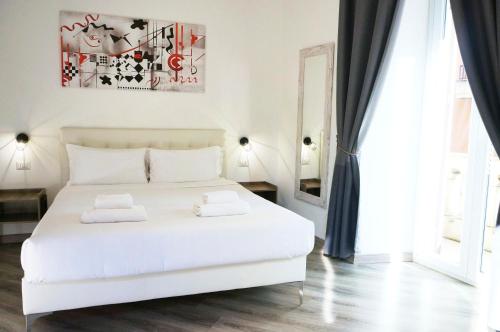 a bedroom with a white bed with two pillows on it at The Roman Way San Giovanni in Rome