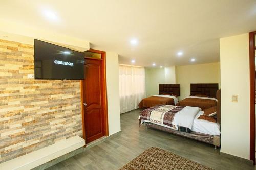 a hotel room with two beds and a flat screen tv at Hotel Explora in Chachagüí
