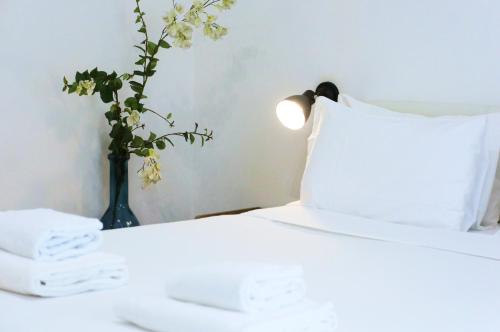 a bedroom with a bed with a vase of flowers at The Roman Way San Giovanni in Rome