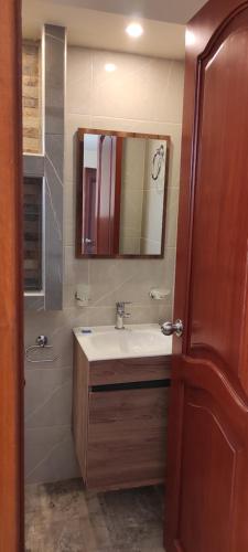 y baño con lavabo y espejo. en Hotel Explora en Chachagüí