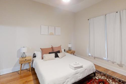 a bedroom with a large white bed and a window at Woodland Wonder in Nashville