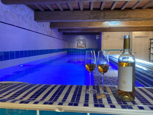 two glasses of wine sitting on a table next to a swimming pool at I SEI FILARI in Capannori