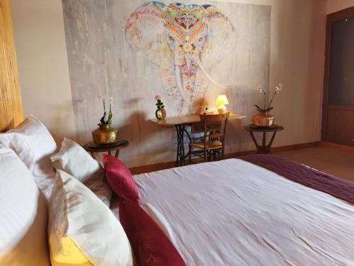 a bedroom with a bed and a painting of an elephant at NOMAD ALP B&B in Marthod