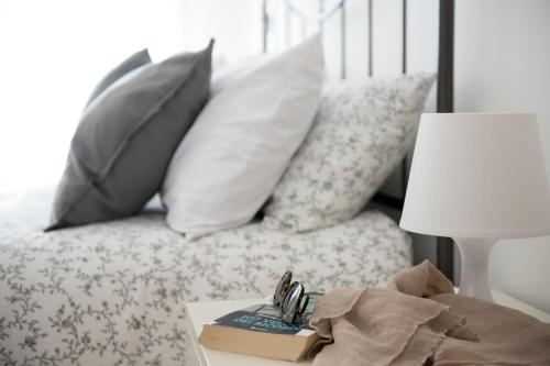 una cama con almohadas y un libro sobre una mesa en Pelèr13, en Riva del Garda