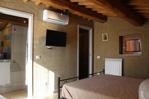 a bedroom with a bed and a tv on the wall at I SEI FILARI in Capannori