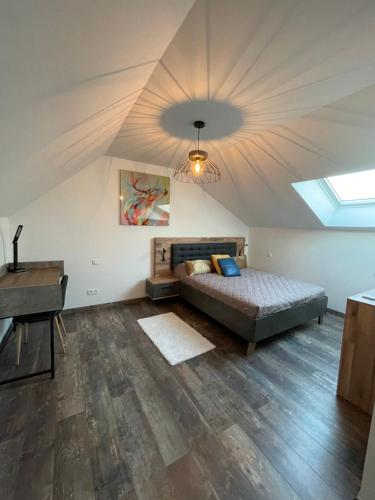 een slaapkamer met een bed, een bureau en een plafond bij Nuits en Sologne in Romorantin