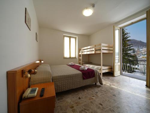 a bedroom with a bed and a desk and a phone at Hotel Skilift - Dada Hotels in Frabosa Soprana