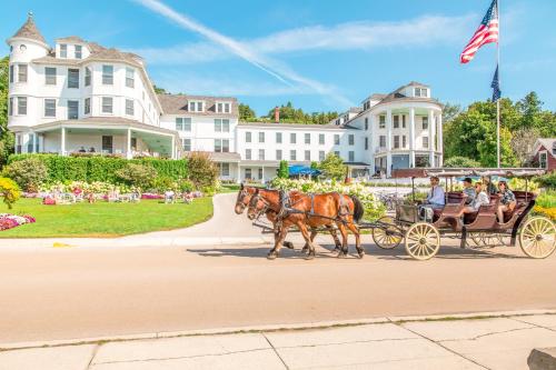 een groep mensen die met paard en wagen rijden bij Island House Hotel in Mackinac Island