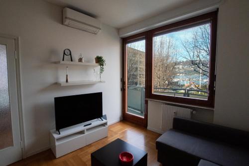 a living room with a large window and a flat screen tv at Il Vicolo in Como