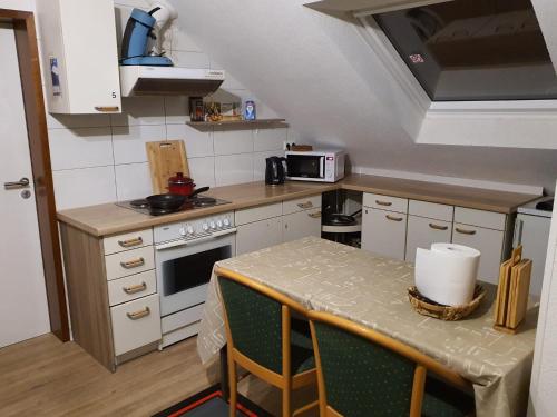 a small kitchen with a table and a stove at Monteurzimmermit Gemeinschafst Bad-Küche- AM RHEIN 