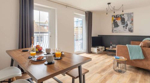 a living room with a table and a couch at Brand New, Stunning, Central Old Town Balcony Flat in Hastings