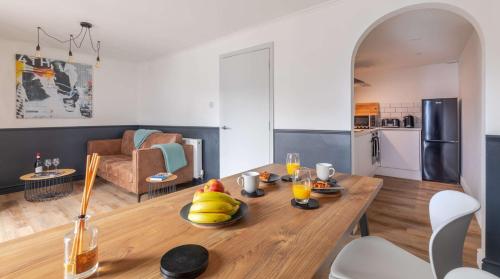 a kitchen and living room with a wooden table with fruit on it at Brand New, Stunning, Central Old Town Balcony Flat in Hastings