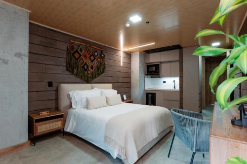 a bedroom with a white bed and a kitchen at Hotel Living by Armoniko in Medellín