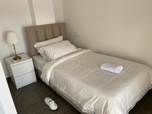 a small bedroom with a bed and a nightstand with a white bedvisor at Golden rays chalet in Madaba