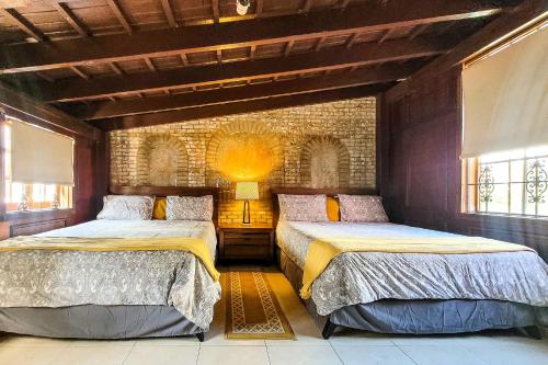 聖胡安的住宿－Luxurious San Juan Villa with Pool - Walk to Beach!，一间卧室设有两张床和砖墙
