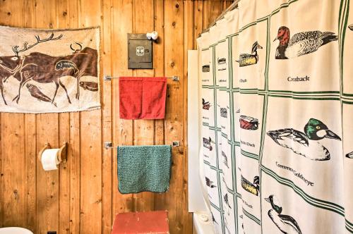 a bathroom with a wooden wall with a shower and towels at Cozy Stop Island Cabin with Boat Dock and Beach! in International Falls