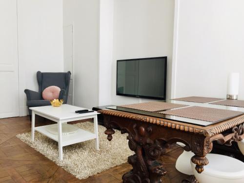 ein Wohnzimmer mit einem Tisch und einem TV in der Unterkunft Appartement Marais in Paris