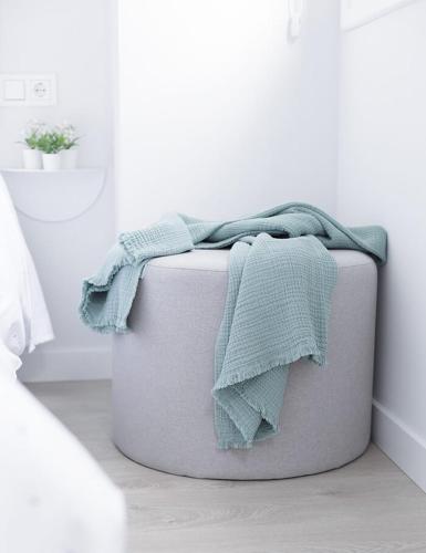 a blanket sitting on top of a suitcase in a room at Apartamentos Nature in Cangas del Narcea