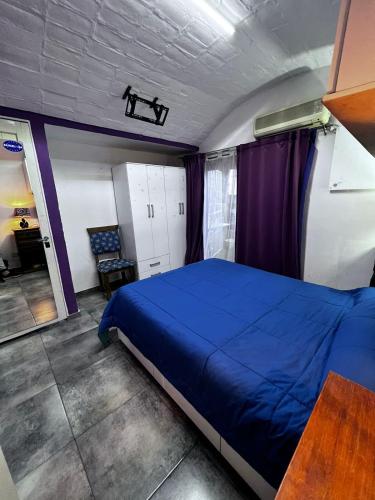 um quarto com uma cama azul e uma cadeira em Winewalker em Ciudad Lujan de Cuyo