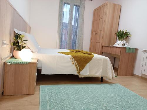 a bedroom with a bed with a yellow blanket on it at Arcobaleno Room Venezia-Mestre in Mestre
