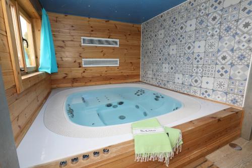 un jacuzzi dans une pièce aux murs en bois dans l'établissement Mobil Home XXL 4 chambres - Camping Le Clos Cacheleux, à Miannay