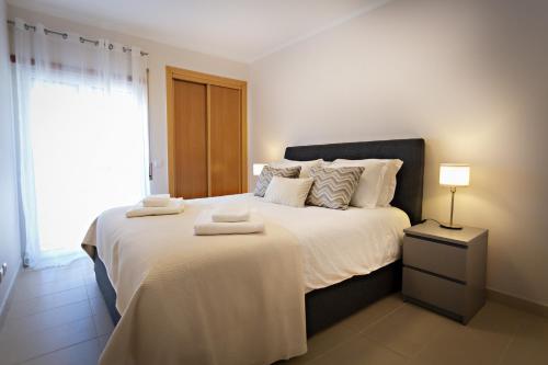 1 dormitorio con 1 cama grande y toallas. en Welcome Cabanas Beach en Cabanas de Tavira