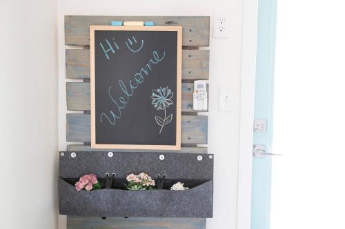a chalkboard wall with flowers and a chalkboard sign at Casa Limonada Boutique Motel in Sarasota