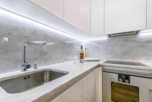 a kitchen with white cabinets and a sink at Modern Flat in Downtown Lisbon by LovelyStay in Lisbon