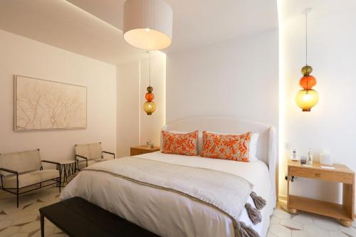 a bedroom with a large white bed with orange pillows at LOtel-Casa Arca in San Miguel de Allende