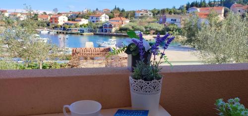 a vase with flowers sitting on a table with a view of a river at Sandy Beach Studio in Lukoran