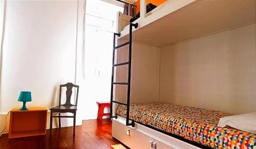 a bedroom with a bunk bed and a chair at Aveiro Rossio Hostel in Aveiro