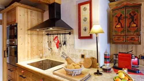 a kitchen with a stove and a bowl of fruit on a counter at Remparts de Riquewihr - Le Grand Cerf in Riquewihr