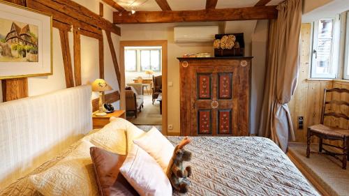 une chambre avec un lit et une chaise dans une pièce dans l'établissement Remparts de Riquewihr - Le Grand Cerf, à Riquewihr