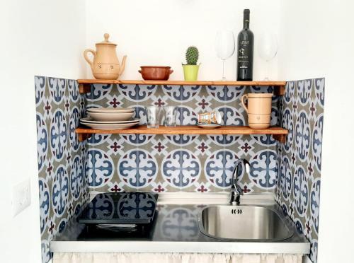 a kitchen with blue and white tiles and a sink at Casina Pompiliano in Nardò